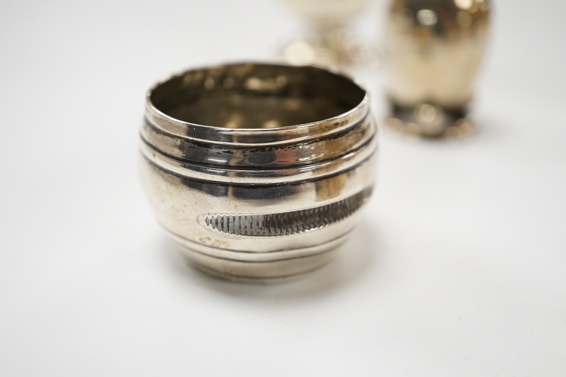 A George V silver mustard pot, London, 1931, with blue glass liner and associated silver shovel, together with a George V silver pepperette, a pair of small silver mustard pots and spoons, a pair of small silver pepperet